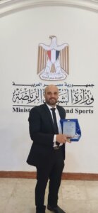 محمد الجرزاوي حاملاً درع التكريم تقديراً لإسهاماته في الإعلام والصحافة التنموية