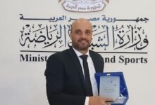 محمد الجرزاوي حاملاً درع التكريم تقديراً لإسهاماته في الإعلام والصحافة التنموية