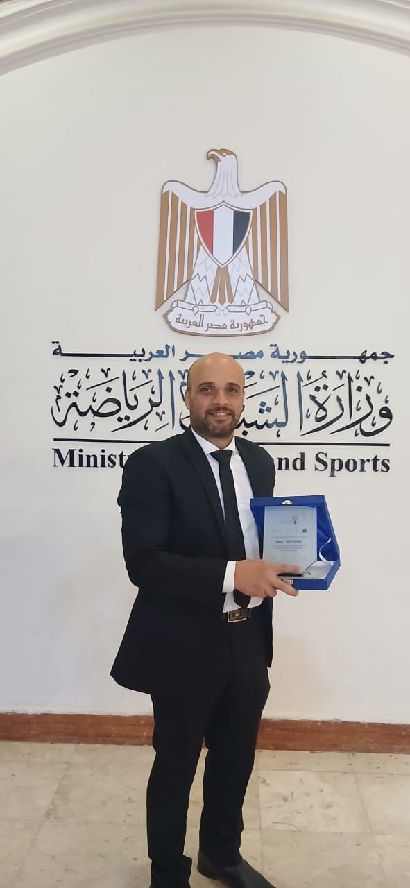 محمد الجرزاوي حاملاً درع التكريم تقديراً لإسهاماته في الإعلام والصحافة التنموية